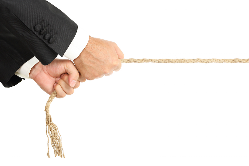 businessman pulling a rope isolated on white